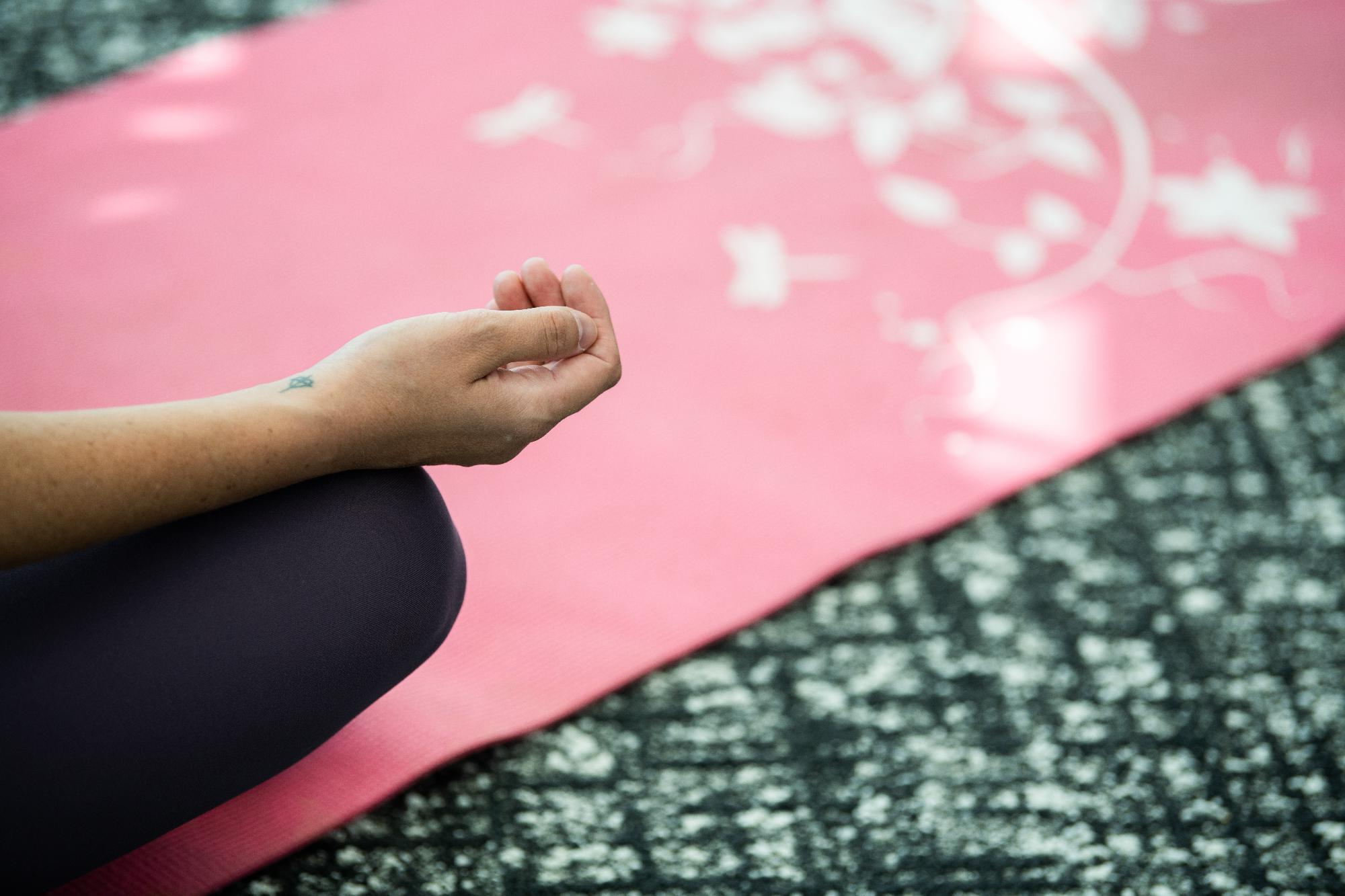 Image of a yoga mat and a person in a seated yoga pose